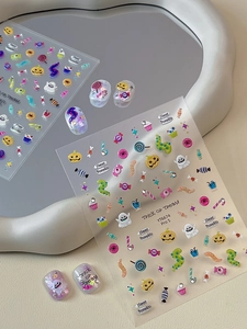Macro detail of 3D Halloween nail stickers with pumpkins, ghosts and glitter motifs