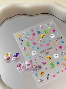 Macro shot of 3D Halloween nail stickers with ghosts and pumpkins on a mirror tray