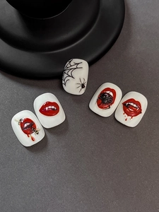Detail of Halloween nail decals featuring vampire red lips and 3D spider web designs