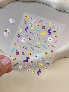 Detail showing 3D Halloween nail stickers with pumpkins, ghosts, and candy patterns