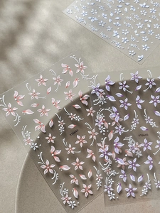 Macro di adesivi per unghie con rilievo 3D, petali rosa e viola e trame floreali fini