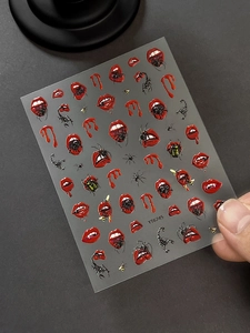 Detail of gothic Halloween nail stickers with red lips, spiders and vampire fangs