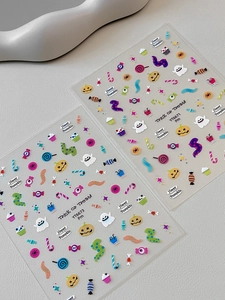 Detail view of Halloween nail decals with pumpkin, ghost, and candy patterns in vivid colors