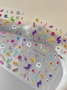 Detail of colorful Halloween nail stickers with pumpkins, ghosts and candy motifs