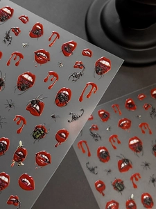 Macro detail of 3D embossed Halloween nail stickers with red lips and spider patterns