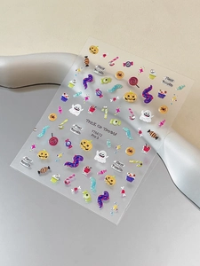 Close-up of colorful Halloween nail art stickers with pumpkin, ghost and candy designs