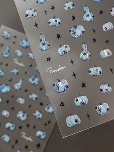 Macro shot of 5D embossed nail stickers featuring blue pumpkins and black stars