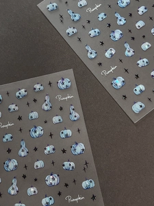 Detailed 3D embossed nail stickers featuring blue pumpkins and black stars texture