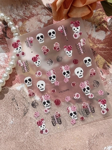Close-up of Halloween nail art stickers featuring skull and rose motifs in 3D relief