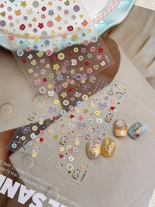 Detail of 3D embossed bear and button nail art stickers with colorful hand-drawn patterns