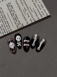 Detail of 3D gothic skull and bone nail stickers with black base on vintage newspaper