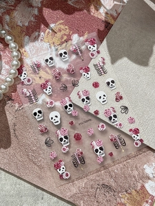 Detailed view of 5D embossed nail stickers with skull, rose, and bone textures
