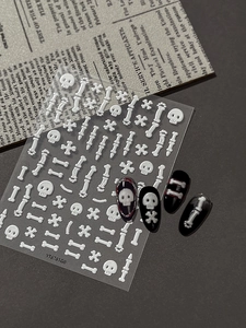 Macro view of 5D embossed Halloween skull and bone nail stickers on black base