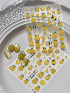 Detail of summer pineapple nail art stickers with embossed yellow fruit slices on white plates