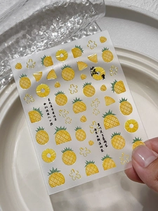 Detail of embossed pineapple nail art stickers with floral patterns and artistic calligraphy