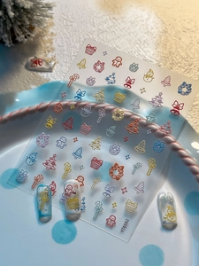 Detail showing 3D embossed Christmas nail stickers with cute snowman and tree patterns