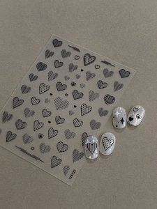 Detail of heart pattern nail stickers with 3D embossed lines on grey finished nails