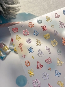 Detail of 3D embossed Christmas nail stickers featuring gingerbread men and snowmen