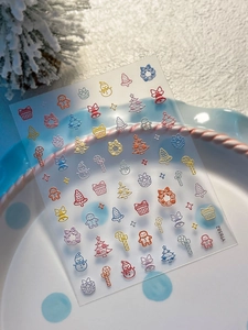 Macro detail of 5D embossed Christmas nail stickers with snowman and gingerbread motifs