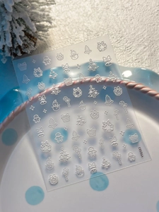 Macro detail of 3D embossed Christmas nail stickers with snowman and tree patterns