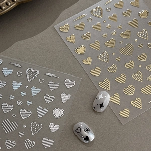 Embossed heart nail stickers in gold and silver with elegant relief line patterns