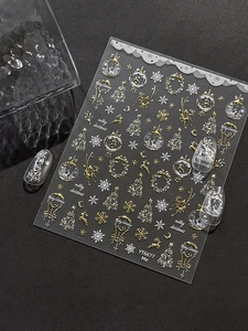 Detail view of 3D gold and silver Christmas nail art stickers with reindeer and snowflakes