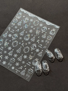 Macro shot of silver laser Christmas nail stickers with snowflakes and reindeer motifs