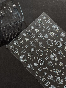 Detailed macro view of laser holographic Christmas nail stickers with snowflake patterns