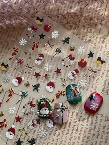 Macro detail of 3D embossed Christmas nail stickers with Santa and snowflake designs