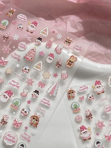 Detail of pink Christmas nail stickers featuring Santa, reindeer and snowflake patterns