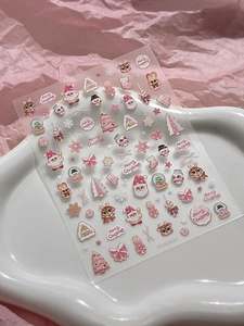 Macro shot of pink Christmas 3D embossed nail stickers with Santa and reindeer motifs