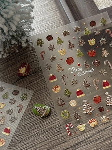 Detail of 3D embossed Christmas nail stickers with tree and gingerbread house motifs