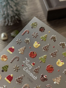 Detail view of 3D embossed Christmas nail art stickers featuring ginger houses and bears