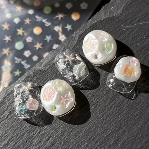 Meeres-Thema Nageltattoo mit 3D Muscheln Seesternen und Perlen auf Schieferplatte