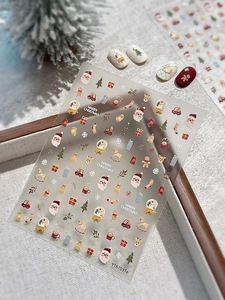 Close-up of Christmas nail art stickers featuring Santa Claus, snowmen and festive trees