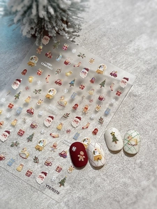 Detailed view of Christmas nail art stickers featuring Santa and snowflake patterns
