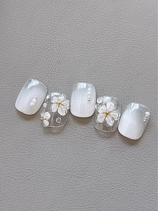Detail of 3D floral nail stickers with white gradient, pearls and gold metallic accents