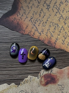 Close-up of 3D Halloween nail stickers with Grim Reaper and pumpkin relief on vintage paper