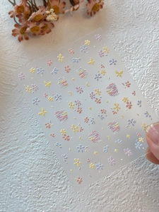 Dettaglio macro di adesivi per unghie con fiori e luna in rilievo e trama goffrata