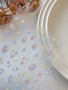 Dettaglio macro di adesivi per unghie con fiori macaron e luna e trama a rilievo