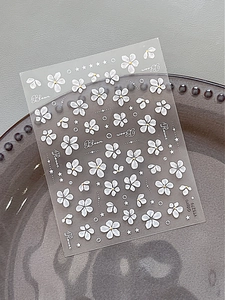Detail view of floral nail stickers featuring white flowers and gold accents on YT5279
