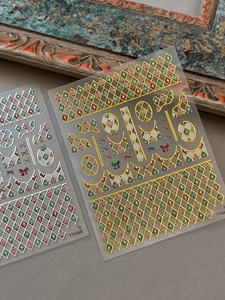 Detailed view of festive gold and silver grid nail art stickers with snowflake motifs