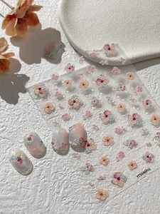 Detail view of 3D embossed floral nail art stickers with relief texture on clear nails