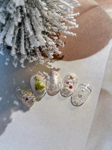 Détail de nail art de Noël en 3D avec sapins et flocons sur vernis blanc perlé