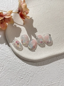 Detailed view of 3D embossed floral nail art stickers with pastel colors and pearl accents
