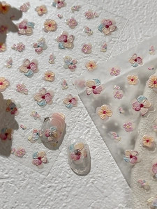 Macro shot of 3D embossed floral nail stickers in macaron colors and petal texture