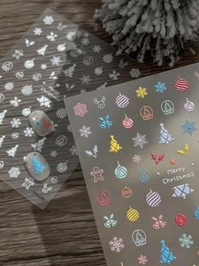 Detailed macro view of 3D embossed Christmas nail art stickers with snowflake designs