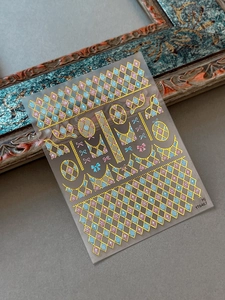 Macro detail of geometric gold foil nail stickers with pink bows and starry patterns
