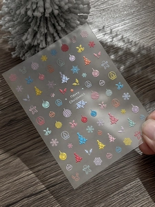 Detail showing 5D embossed Christmas nail stickers with colorful festive patterns