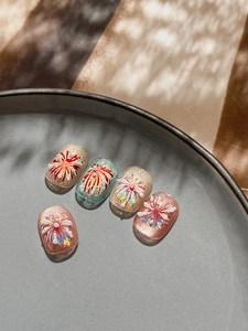 Detailed view of handmade press-on nails with 3D fireworks, pearls, and cat-eye glitter